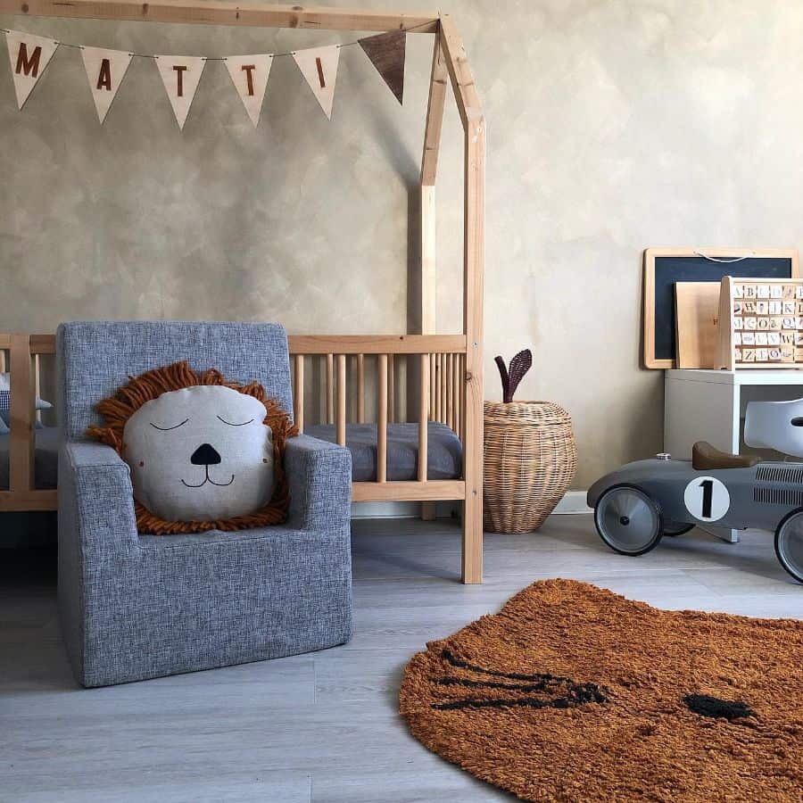 Cozy child's room with a crib, armchair with a lion pillow, toy car, and alphabet board