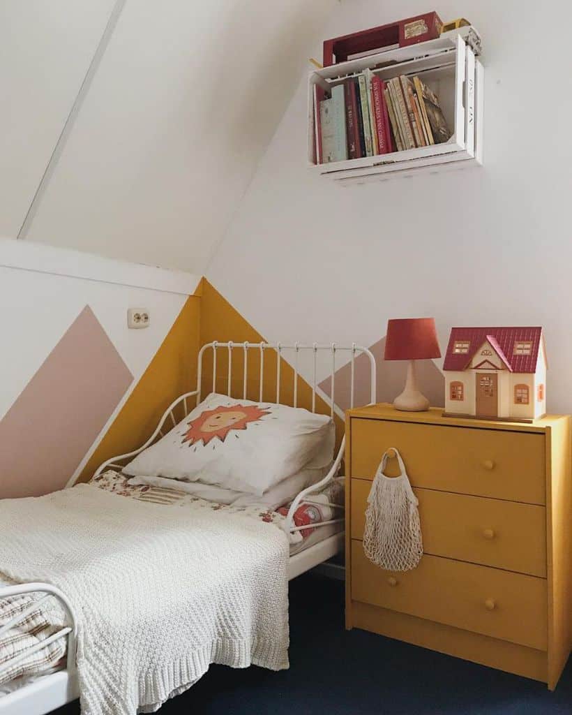 Cozy child's bedroom with a small bed, lion pillow, yellow dresser, and books on a wall shelf