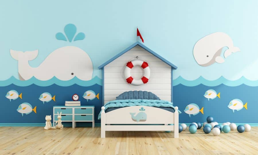 Kids' bedroom with nautical theme, whale wall art, and boat-shaped bed.