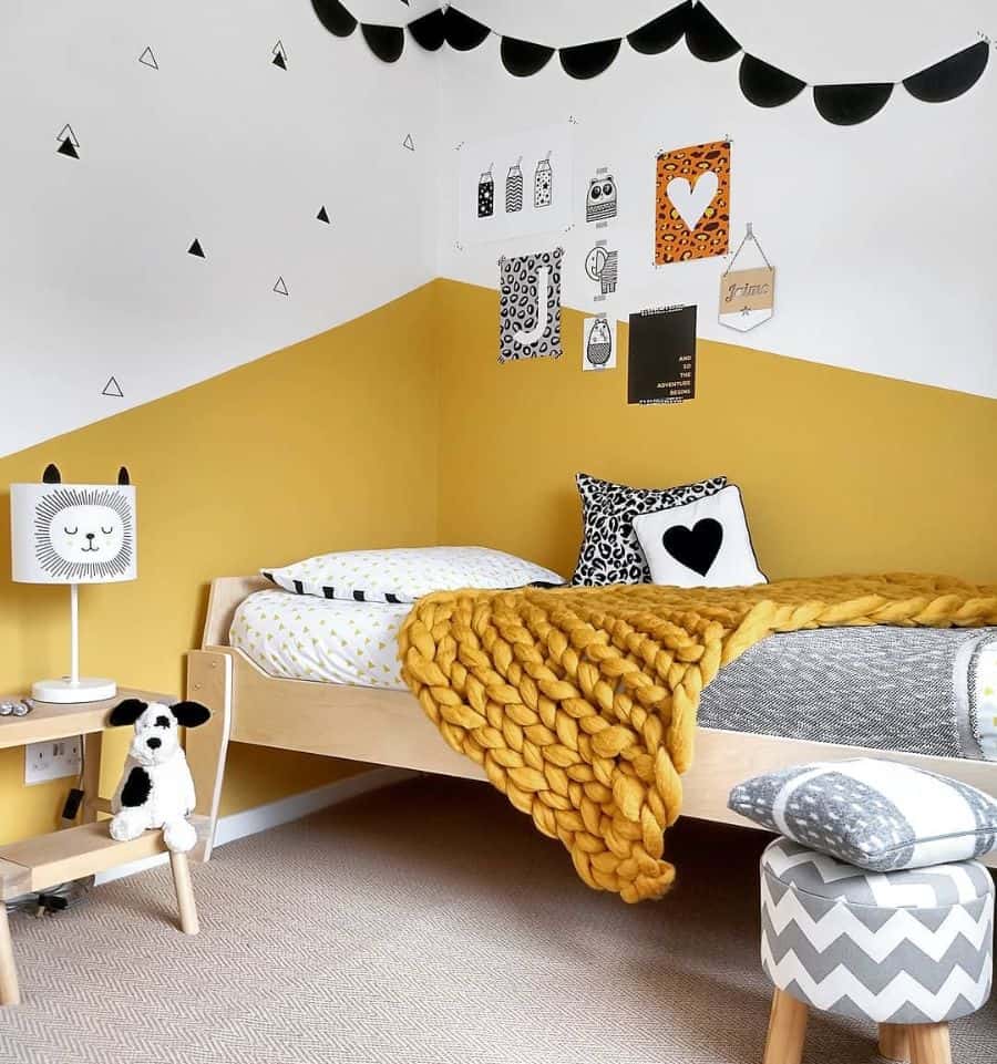 Children's bedroom with vibrant yellow accents, a cozy bed, and playful decorations on the walls