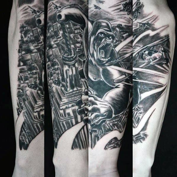 Detailed black and grey King Kong sleeve tattoo showing Kong rampaging through a city, battling planes in an intense action scene.