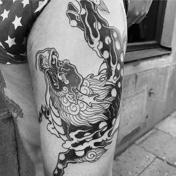 Black and grey Kirin tattoo on the thigh with bold contrasts, swirling mane, and dynamic movement for a fierce traditional look.