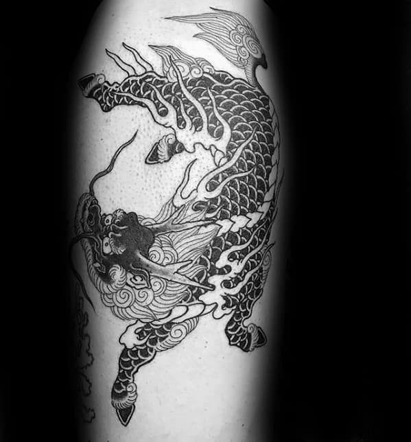 Black ink Kirin tattoo with flowing flames, intricate scales, and a fierce expression, captured mid-leap in a bold traditional style.