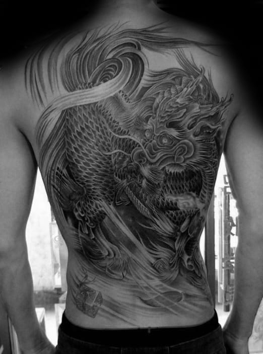 Full-back Kirin tattoo in black and grey with detailed shading, swirling wind effects, and a fierce expression on the mythical creature.