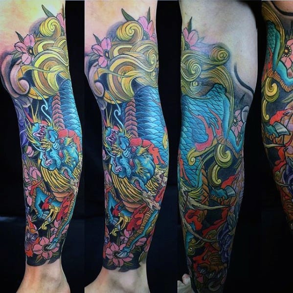 Colorful full-leg Kirin tattoo with bright blue scales, golden mane, red flames, and pink cherry blossoms in a vivid Japanese style.