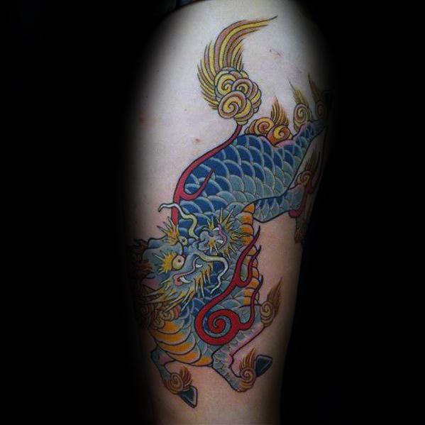 Vibrant Kirin tattoo with blue scales, golden mane, and red accents, captured mid-stride in a bold and colorful traditional design.
