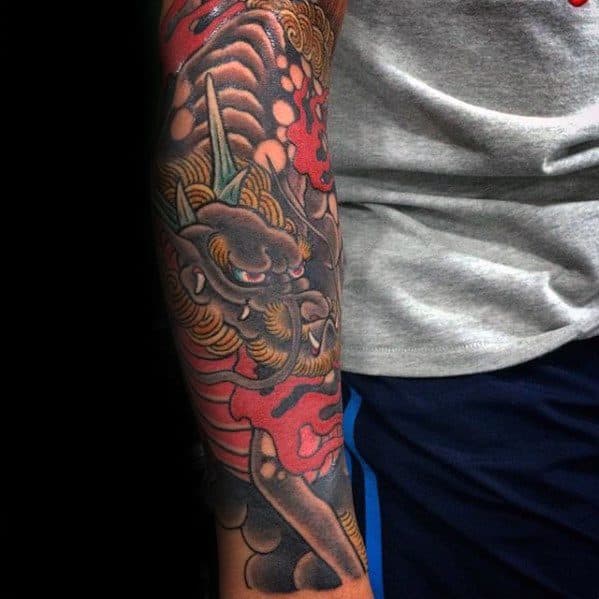 Colorful Kirin sleeve tattoo with golden mane, red flames, and detailed scales, wrapping the arm in a bold and powerful design.