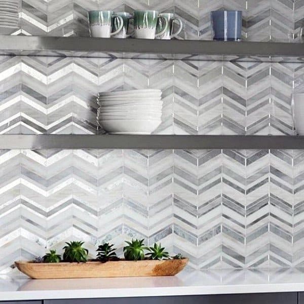 Chevron-patterned backsplash adds texture and depth to this modern kitchen setup.