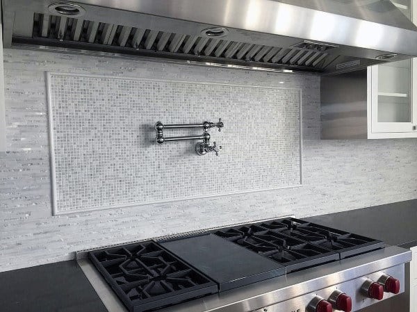 Stainless steel range with white mosaic tile backsplash and built-in pot filler faucet.