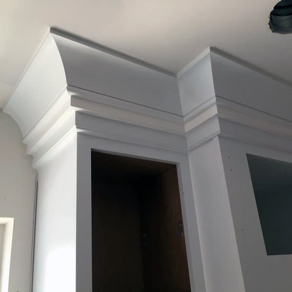 A close-up of kitchen cabinets with sleek white crown molding, adding a refined and polished touch to the space