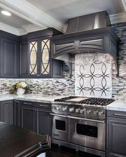 gray kitchen cabinets with unique splashback and tile wall