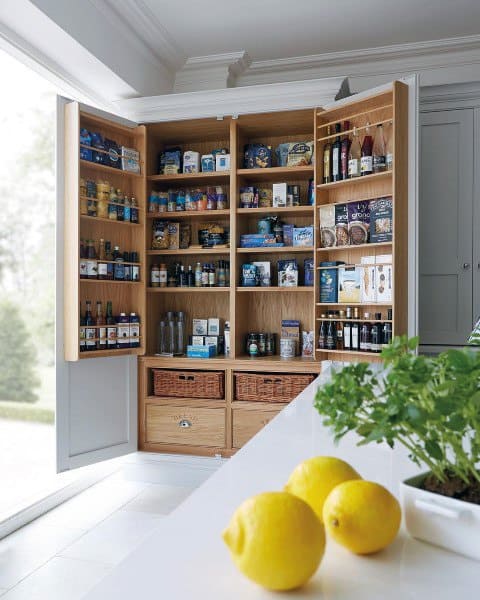 Open wooden pantry cabinet with organized shelves and wicker baskets.