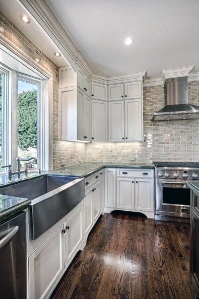 corner kitchen with white cabinets concrete apron sink and hardwood floors 