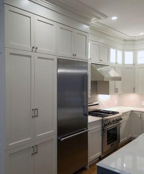 A modern kitchen featuring sleek cabinetry, stainless steel appliances, and clean white crown molding for an elegant finish