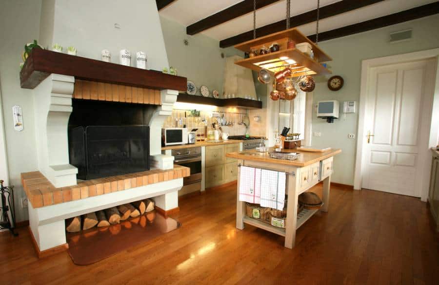country style kitchen copper pots and pans hanging from the roof fireplace wood island with drawers