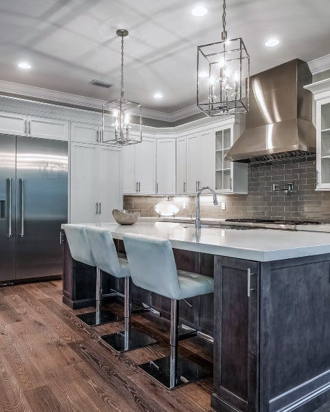 Modern kitchen with stainless steel appliances, white cabinets, island seating, and pendant lights