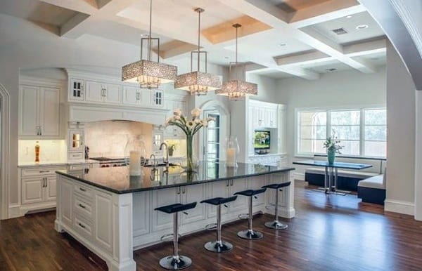 Spacious modern kitchen with an island, bar stools, pendant lights, and a cozy breakfast nook by the window