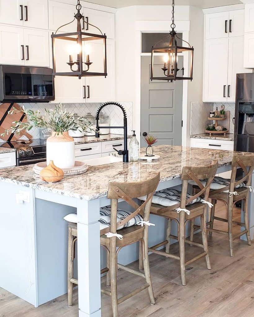 white cabinet farmhouse kitchen with vintage chairs around island