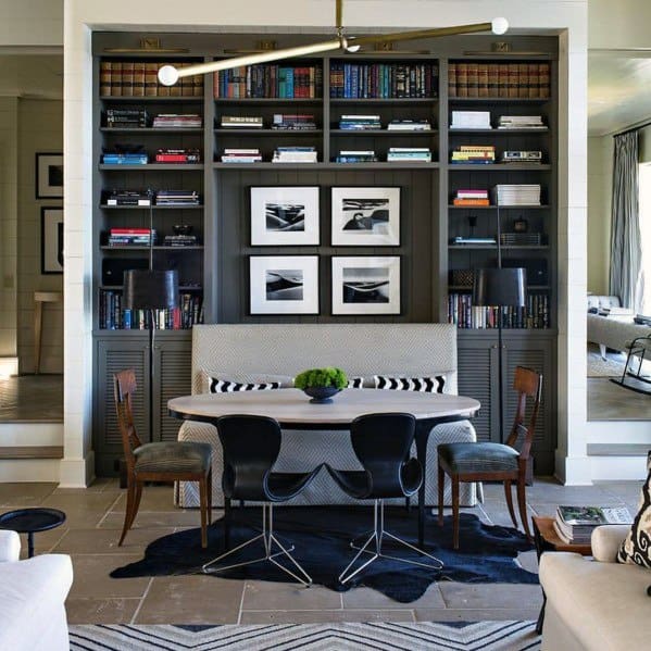 Stylish dining nook with gray built-in bookcases, modern lighting, black chairs, and framed black-and-white artwork