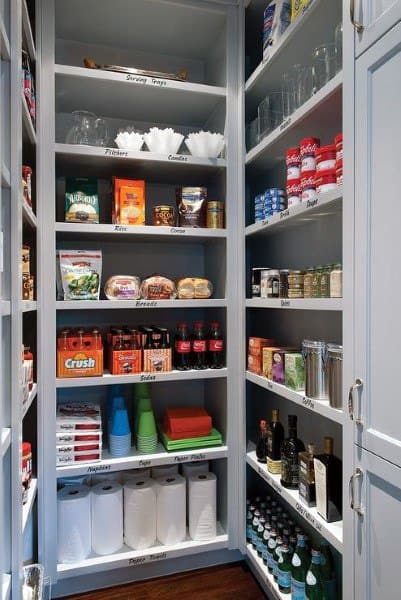 Organized kitchen pantry with labeled shelves, light gray cabinetry, and neatly arranged food and kitchen supplies.