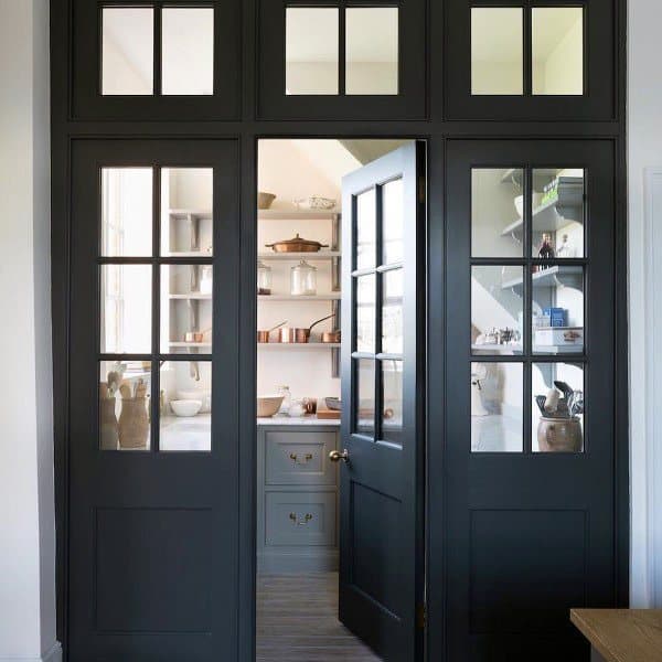 Glass-paneled black doors leading to a neatly organized kitchen pantry.