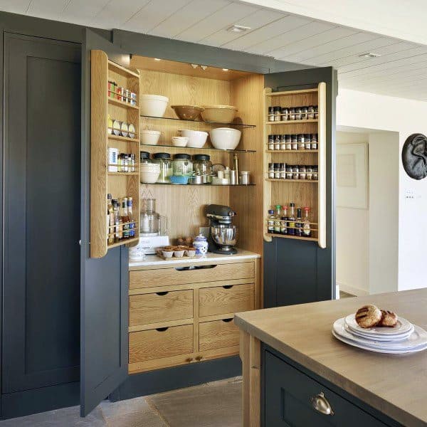 Wooden pantry cabinet with spice racks, open shelves, and built-in drawers.