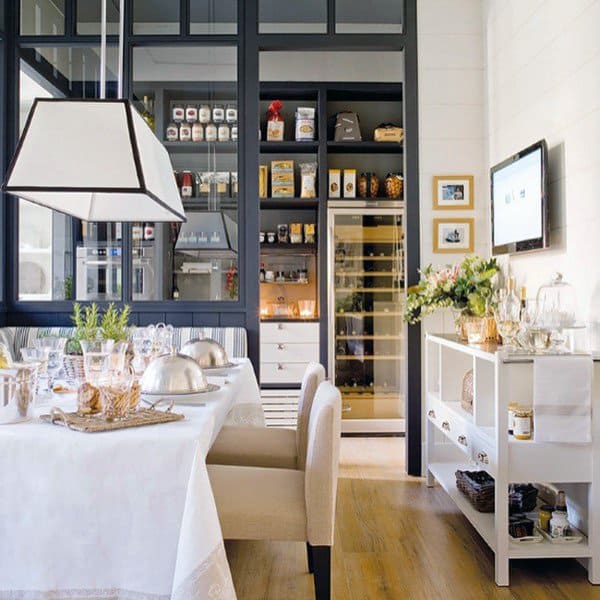 Elegant dining area with a glass-enclosed pantry and organized shelves in the background.