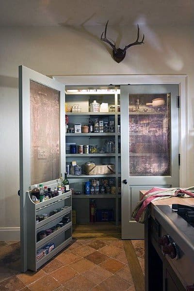 A farmhouse-style kitchen pantry with glass-paneled doors and ample shelves for organized storage.