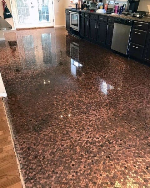 Kitchen with glossy penny tile flooring, dark cabinets, and stainless steel appliances.