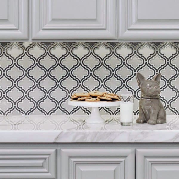 This intricate Moroccan-style backsplash adds a bold, decorative flair to the classic grey cabinetry.