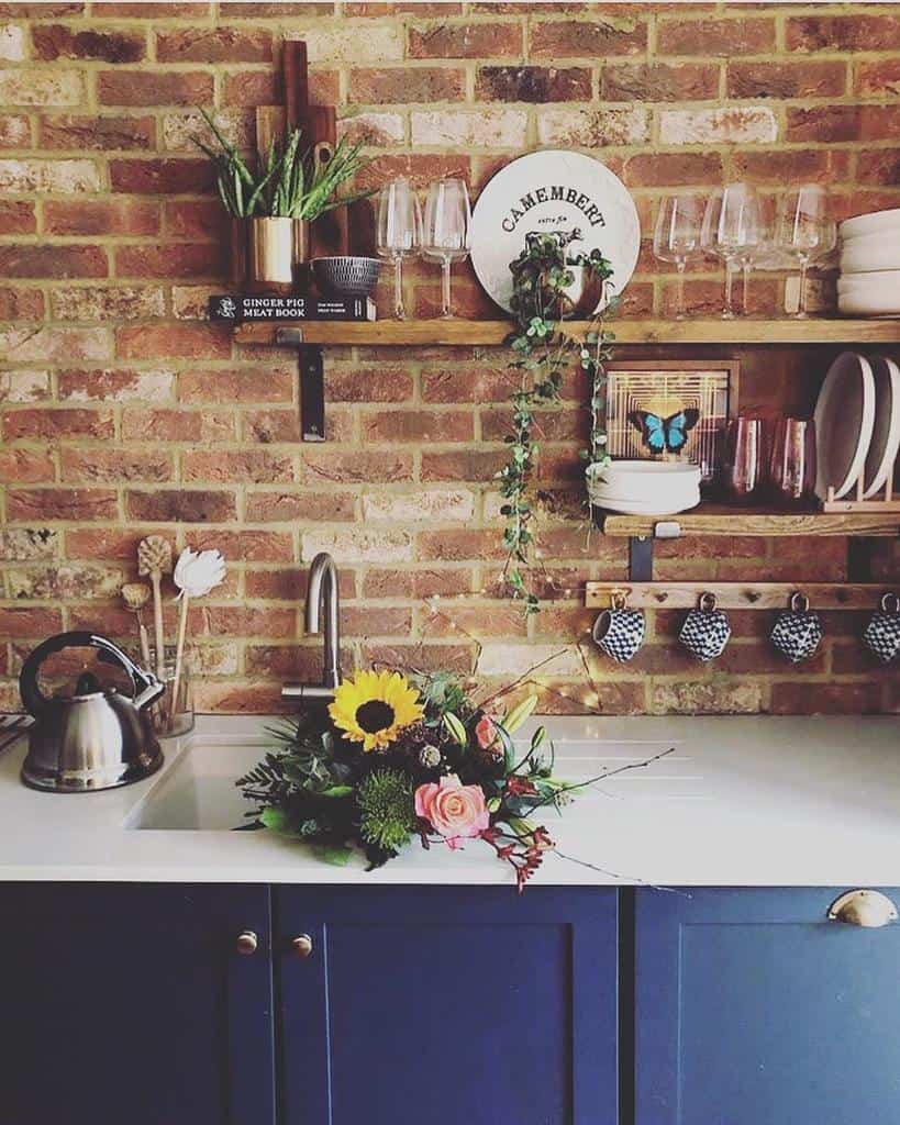 brick wall kitchen wood wall shelves blue cabinets