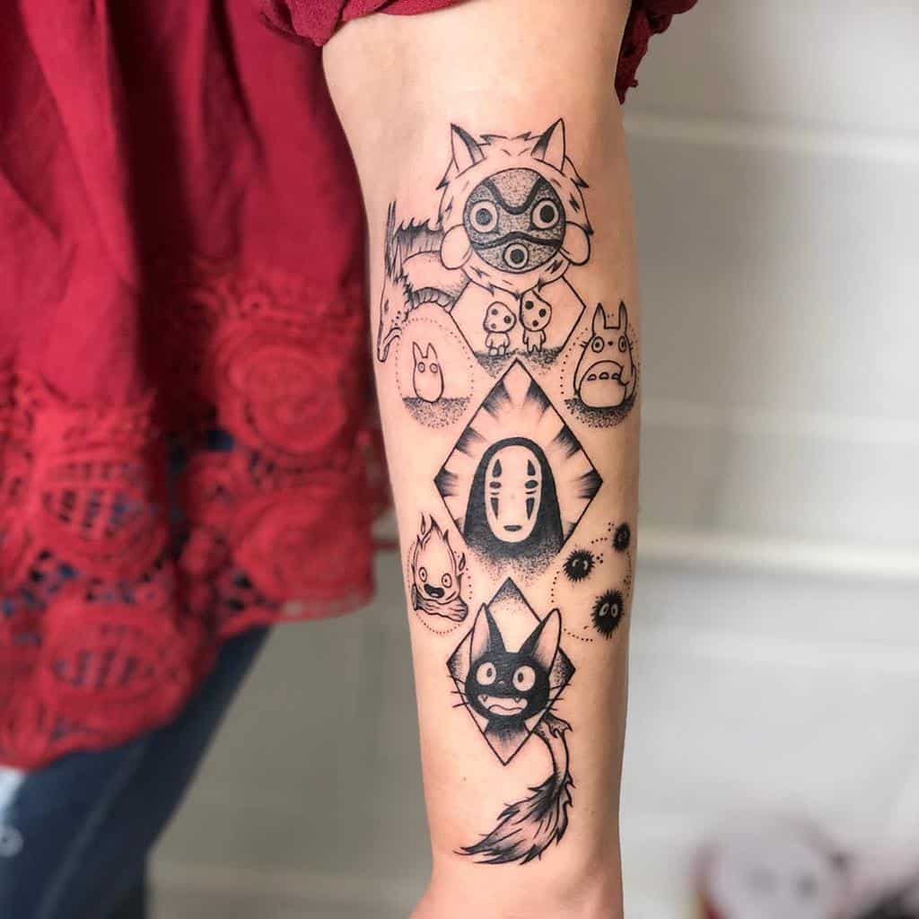 Black and grey tattoo featuring characters from Studio Ghibli films, including Haku, No-Face, Jiji, Totoro, Kodama, San, and soot sprites in a geometric layout