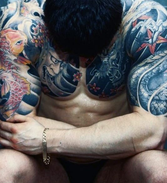 Man with colorful, detailed tattoos on his arms and chest