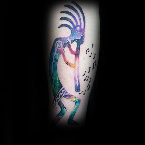 Vibrant Kokopelli tattoo with a galaxy-themed body and flowing music notes, blending cosmic art with tribal symbolism.