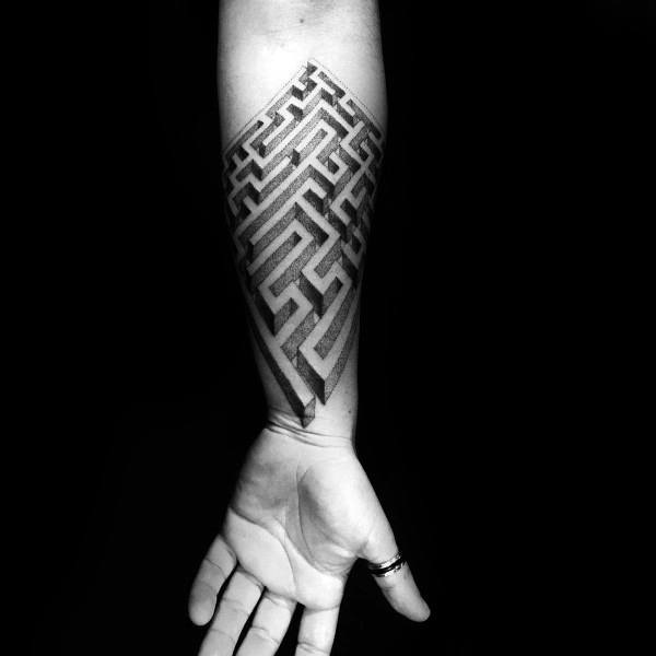 Geometric blackwork labyrinth tattoo on a man's forearm, featuring a bold 3D maze design in a diamond shape with intricate shading.