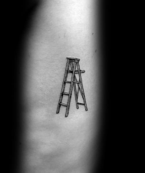 Minimalistic tattoo of a small folding ladder, symbolizing practical ambition, perfect for subtle placements on men's ribs or arms.