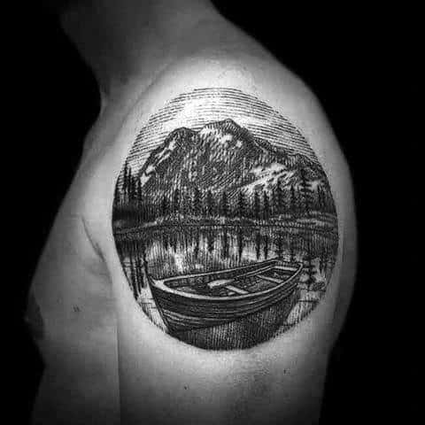 Detailed shoulder tattoo of a rowboat on a calm lake, surrounded by pine trees and snow-capped mountains in an engraved sketch style.