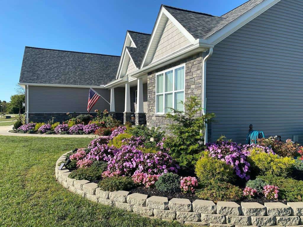 landscaped flower garden stone retaining wall grass