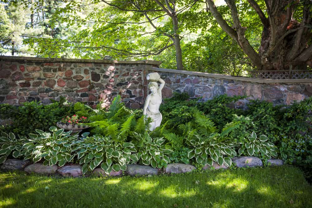 landscaped garden with female stone statue 