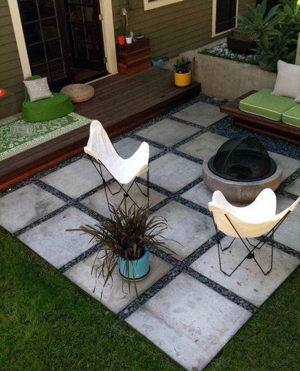 Modern patio with two white chairs, a fire pit, and a potted plant on tiles beside a wooden deck