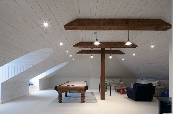 Spacious attic game room with pool table, exposed wooden beams, and cozy seating area.