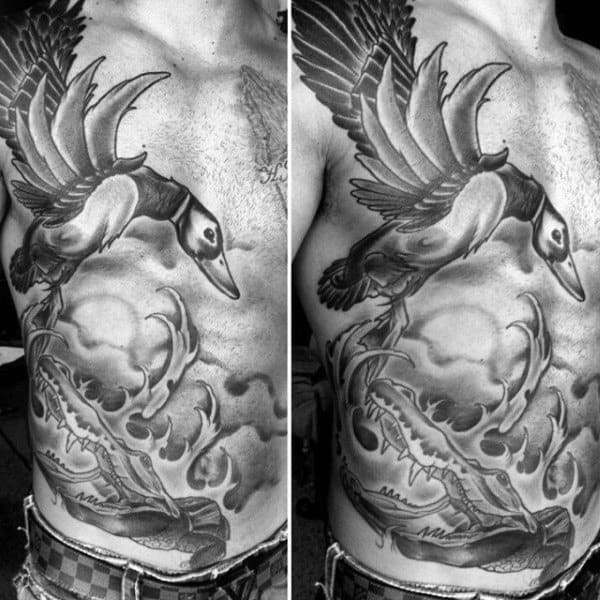 Large Detailed Black And Grey Duck Flying Over Water Tattoo On Guy