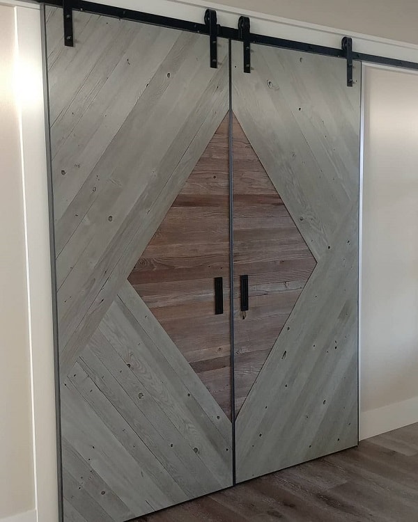 Large double sliding barn doors with a diagonal wood pattern and diamond-shaped center.
