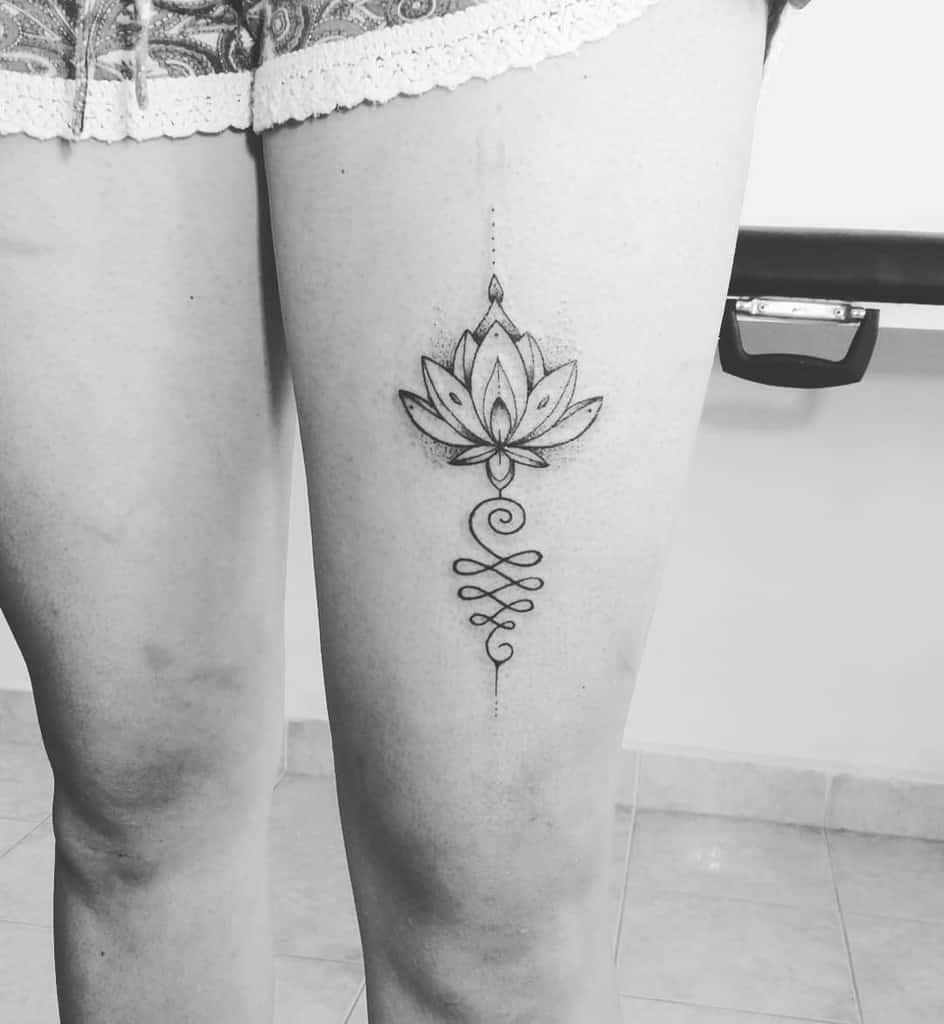 Unalome tattoo with a lotus on the thigh, symbolizing spiritual awakening, resilience, and the journey toward enlightenment and inner peace.