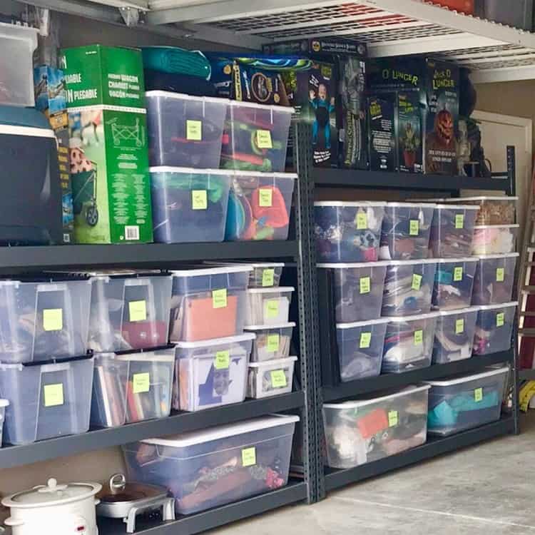 Basement shelves with labeled transparent storage bins and boxed seasonal decorations.