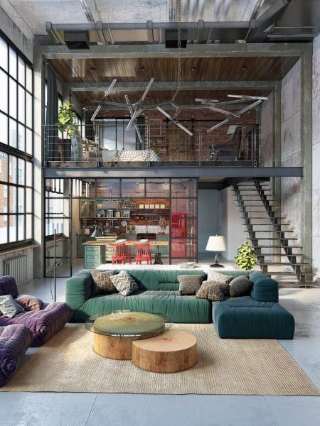 Spacious industrial loft with colorful seating, glass kitchen wall, and mezzanine bedroom area.