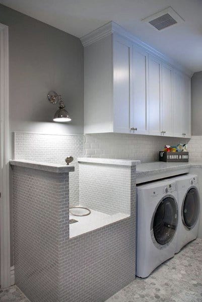 Laundry room with white cabinets, pet washing station, and modern appliances.