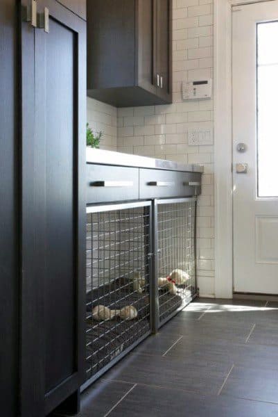 Laundry room with dark cabinets, built-in pet crates, and subway tile backsplash.