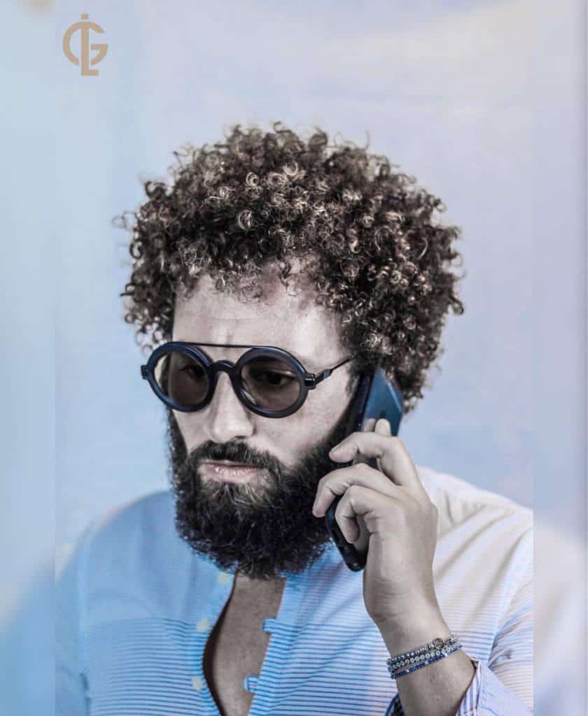 A man wearing layered curly hair with natural volume