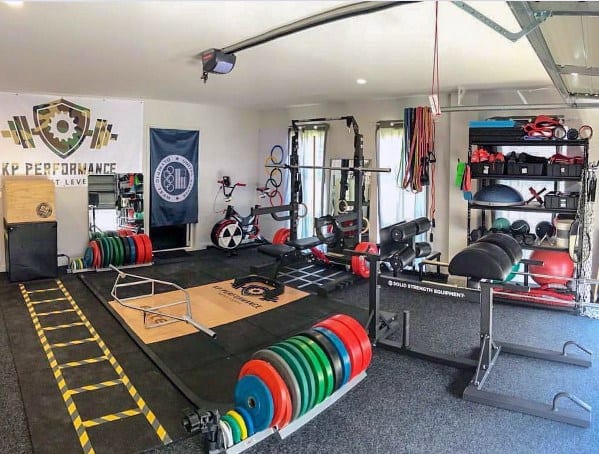 Garage gym with weightlifting equipment, squat rack, resistance bands, and organized storage.